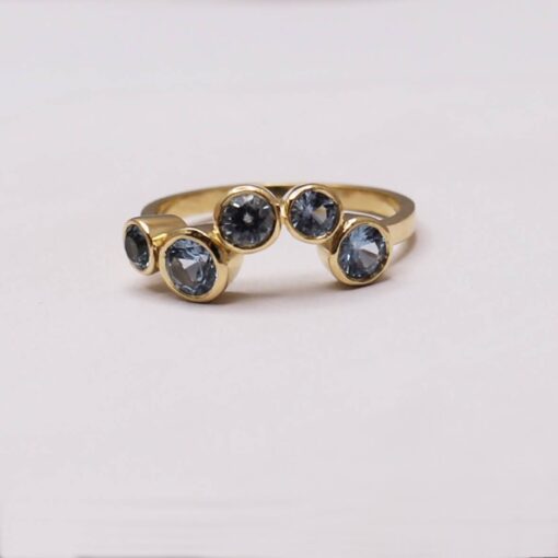 Anillo Calma en oro macizo con cinco topacios azules de distintos tamaños y engaste bisel