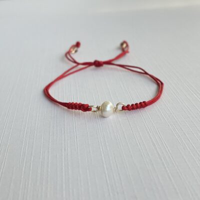 Pulsera Protección con perla natural, cordón rojo ajustable y detalles en goldfilled